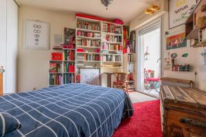 a bedroom with a blue bed and bookshelves at Port Royal Apart de Charme-Parking-Cœur de Ville in Nantes