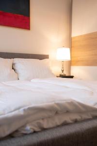 a bedroom with a white bed with a lamp at Gemütliches Apartment direkt am Hafen von Dortmund in Dortmund