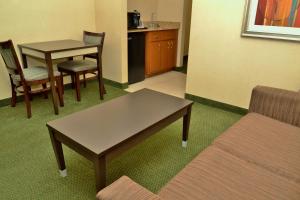 a living room with a couch and a table and chairs at Holiday Inn Express Hotel & Suites Center Township, an IHG Hotel in Monaca