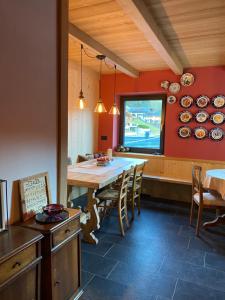 a kitchen with a table and chairs and plates on the wall at B&B CAMPITELLO 13 di Caterina Costan in San Nicolò di Comelico