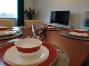 una mesa con platos y cuencos encima en The Hillside Apartment - King's Norton Birmingham en Kings Norton