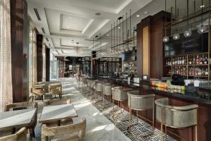 a restaurant with a bar with tables and chairs at The Chateau Grande Hotel in East Brunswick