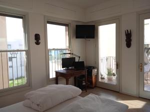 a bedroom with a bed and a desk with windows at Jaffa sea front, luxury Duplex, Port & Old City 2m walk in Tel Aviv