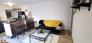 ein Wohnzimmer mit einem Sofa und einem Tisch in der Unterkunft Appartement Cosy au cœur de la Champagne in Cramant