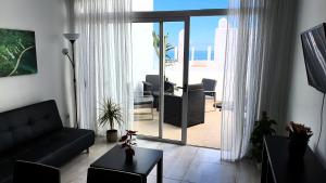 un soggiorno con divano nero e vista sull'oceano di Ocean View Apartments ad Adeje