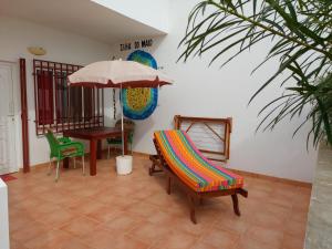 a patio with a chair and an umbrella and a table at Barracudamaio in Morro