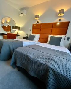a hotel room with two beds and a mirror at Hotel "Księżyc" w Świebodzicach in Świebodzice