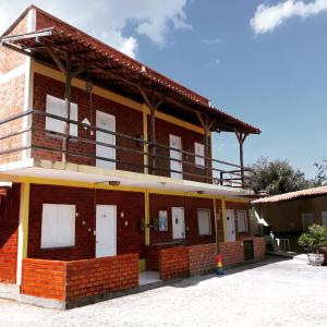 a brick building with white doors and a balcony at Condomínio Porto dos Lençóis - AP02 in Barreirinhas