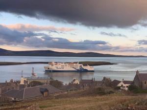 a large cruise ship in a large body of water at Orkney Lux Lodges - Hoy Lodge in Stromness