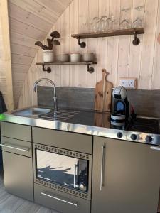 a kitchen with a stove and a sink and a counter top at Orkney Lux Lodges - Hoy Lodge in Stromness