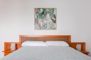 科斯塔特吉塞DARUMA APARTMENTS 2-Bedroom Duplex with Sea Views的卧室里的一张床，墙上挂着一幅画