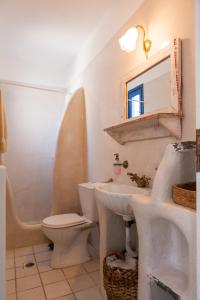 uma casa de banho com um lavatório, um WC e um espelho. em Aegean Paradise, Kythnos, Naousa em Kythnos