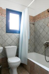 uma casa de banho com um WC, uma banheira e uma janela. em Aegean Paradise, Kythnos, Naousa em Kythnos
