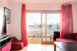 科斯塔特吉塞DARUMA APARTMENTS 2-Bedroom Duplex with Sea Views的客厅配有红色窗帘和滑动玻璃门