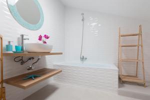 科斯塔特吉塞DARUMA APARTMENTS 2-Bedroom Duplex with Sea Views的带水槽和浴缸的浴室