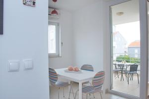 a dining room with a white table and chairs at SunShine in Novalja +10 photos
