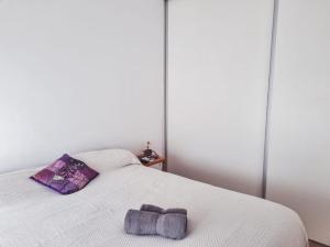 a white bed with a stuffed animal on it at Duplex 571 in Chascomús