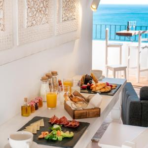 - une table avec de la nourriture et une vue sur l'océan dans l'établissement Porta Nova Suites Altea - Adults Only, à Altea
