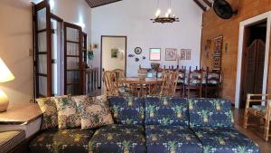 a living room with a couch and a table at Casa com piscina a 350m da praia em Boiçucanga in Boicucanga