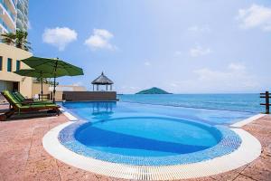 a swimming pool with a view of the ocean at Zafiro Beach Boutique Resort in Mazatlán