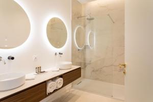 een badkamer met een wastafel en een douche met spiegels bij Les Clés Secrètes in Sète