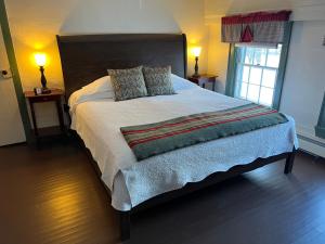 a large bed in a bedroom with two lamps at Shoreham Inn Bed & Breakfast in Shoreham