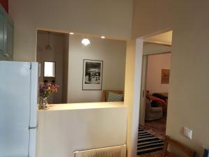 a kitchen with a refrigerator and a living room at Maria's Cozy apartment in Palaio Faliro in Athens