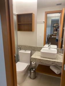 een badkamer met een toilet, een wastafel en een spiegel bij SALINAS PREMIUM RESORT -Apartamento in Salinópolis