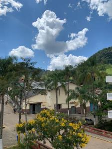 a building with a lot of trees and yellow flowers at Apartamento Estrada Real - Apart Hotel em Marmelópolis in Marmelopolis