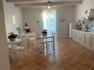 a kitchen with tables and chairs and a kitchen with a refrigerator at B & B La casa dei sogni in Casapulla