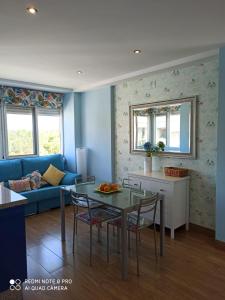a living room with a blue couch and a table at APARTAMENTO EN ROMPIDO con piscina, chiringuito y pistas in Huelva