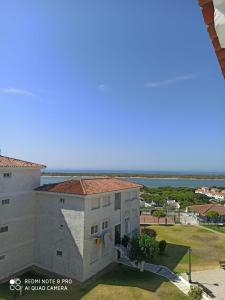 an apartment building with a view of the ocean at APARTAMENTO EN ROMPIDO con piscina, chiringuito y pistas in Huelva