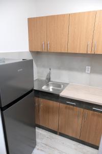 a kitchen with a stainless steel refrigerator and wooden cabinets at Apartman Venezia in Banja Luka
