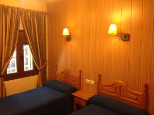 sypialnia z 2 łóżkami pojedynczymi i oknem w obiekcie Hostal Delfin Verde w mieście Almería