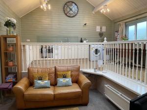 a living room with a couch and a clock on the wall at River View in Buxton