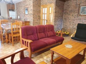a living room with a red couch and a table at Los Guijos in Hoyos del Espino