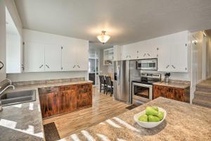 una cocina con armarios blancos y un bol de manzanas en una encimera en Sioux Center Split-Level Home with Game Room!, en Sioux Center