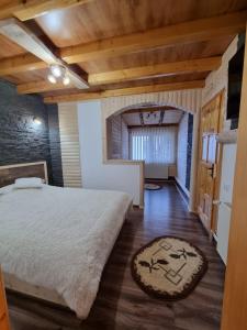 1 dormitorio con cama grande y techo de madera en Zumzetul Raului, en Rucăr