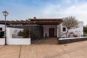 budynek z bramą i kamienną ścianą w obiekcie Villa Axular w mieście Playa Blanca