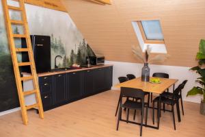 a kitchen with a table and chairs and a ladder at Agroturystyka Bocian Biały in Kiwity