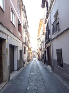 una strada vuota in un vicolo tra gli edifici di BONITO AP CENTRICO PATIO WIFI PARKING GRATIS. a Granada