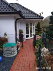 ein Haus mit einem Ziegelsteinweg, der auf eine Terrasse führt in der Unterkunft Ferienwohnung Christine in Jever