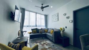 a living room with a blue couch and a tv at Depa lujoso cerca del malecón by G P S rentas in Mazatlán