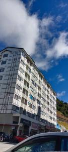 a large white building with cars parked in front of it at The Sky - The Cave Guest House in Tanah Rata +18 photos