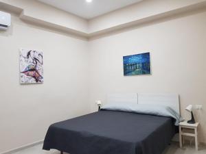une chambre avec un lit et deux tableaux au mur dans l'établissement La Sapienza, à Naples