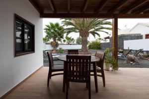 stół i krzesła na patio z palmami w obiekcie Villa Axular w mieście Playa Blanca