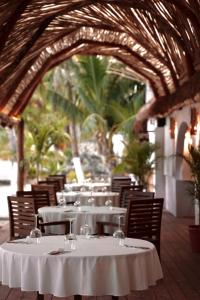 a table with white tables and chairs in a restaurant at Alito Tulum Hotel in Tulum