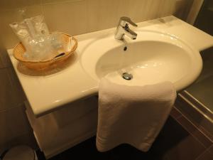 a white bathroom sink with a white towel on it at Hotel Motel Piu' in Vaiano Cremasco