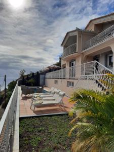 einen Balkon eines Hauses mit Liegestühlen darauf in der Unterkunft Casa Del Mar in Ponta do Sol