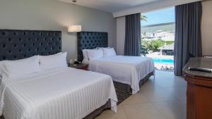 a hotel room with two beds and a balcony at Holiday Inn Tuxtla Gutierrez, an IHG Hotel in Tuxtla Gutiérrez